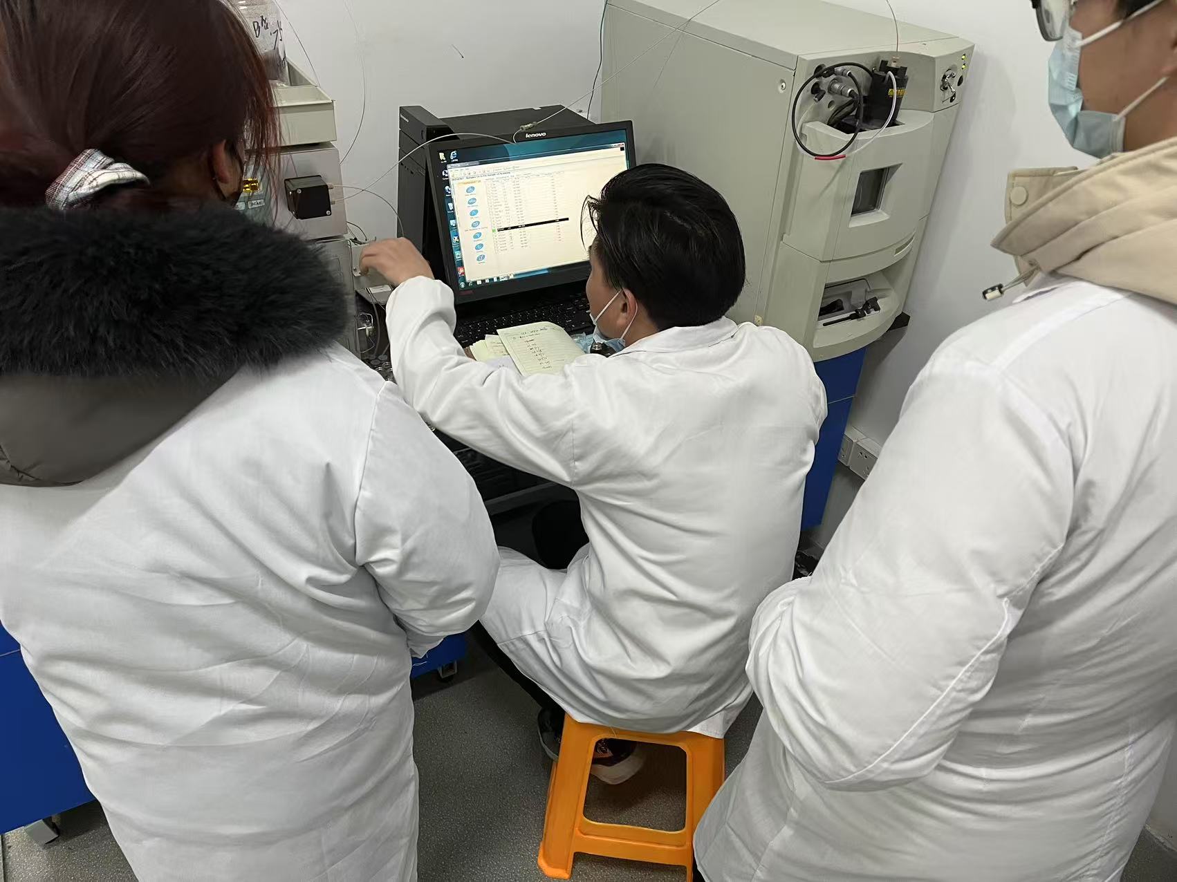 Laboratory team at an instrument in authorized source archive